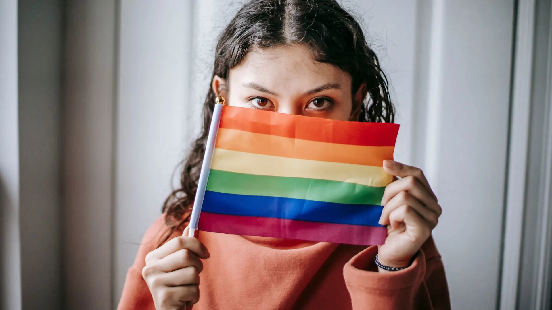 Young ethnic woman with colorful LGBT flag